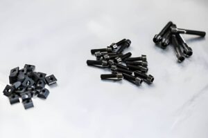 Anodized titanium nuts and bolts on a silver background