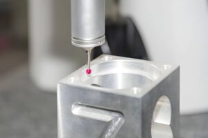The CMM machine probe inspecting a machined part