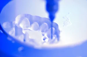 A dental milling machine is carving out the shape of human teeth